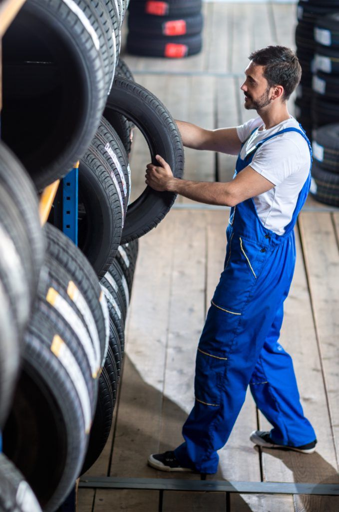 Mechanic picking up a tyre from stock - Galashiels Tyres